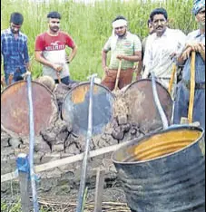  ?? HT PHOTO ?? An excise department team with the seized drums on the banks of the Sutlej in Tarn Taran district.