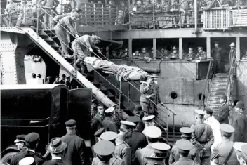  ??  ?? The long journey to recovery: a wounded man is carried to a waiting ambulance in Wellington; left, barges carrying the Gallipoli wounded out to transports.