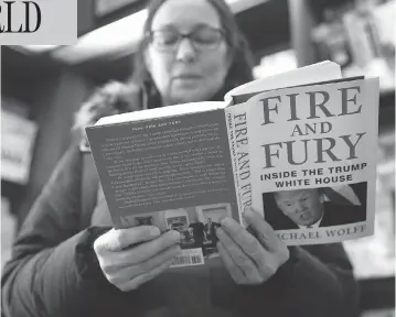  ?? CHARLES REX ARBOGAST / THE ASSOCIATED PRESS ?? Kathy Mallin, from Glenview, Ill., looks over a copy of the book Fire and Fury: Inside the Trump White House by Michael Wolff at Chicago’s Barbara’s Bookstore on Friday, the day that it went on sale.