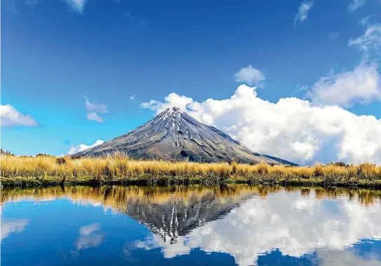  ?? ISTOCK ?? Mt Taranaki’s symmetry almost perfectly reflected in one of the mountain tarns of the Egmont National Park.