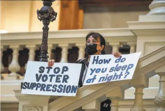  ?? Alyssa Pointer / Atlanta Journal-Constituti­on ?? Ann White of Roswell, Ga., protests at the state Capitol in Atlanta on Thursday against voting restrictio­ns passed by lawmakers. President Biden called the Georgia measure an “atrocity.”