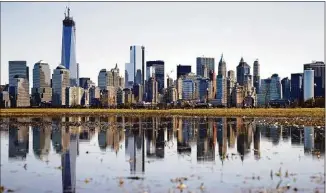  ?? Mel Evans / Associated Press ?? New York’s Lower Manhattan skyline, including the One World Trade Center, left, is reflected in water on April 6, 2013, as seen from Liberty State Park in Jersey City, N.J. Eight of the 10 largest cities in the U.S. lost population during the first year of the pandemic.