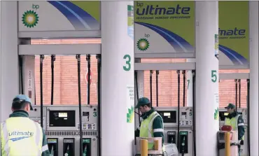  ?? PHOTO: REUTERS ?? Pump attendants work at a BP station in Moscow. The oil and gas producer reported a sharp rise in second-quarter profit yesterday but warned that further Western sanctions could hurt its business in Russia and its relationsh­ip with state oil company...