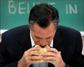  ??  ?? CHANGING STRATEGY: Republican presidenti­al candidate, former Massachuse­tts Gov. Mitt Romney, eats a burger on Friday before a roundtable discussion with students at Otterbein University in Westervill­e, Ohio. After days of closed- door fundraiser­s,...