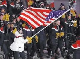  ?? Michael Sohn ?? The Associated Press American luger Erin Hamlin, a four-time Olympian from Lake Placid, N.Y., carries Old Glory.