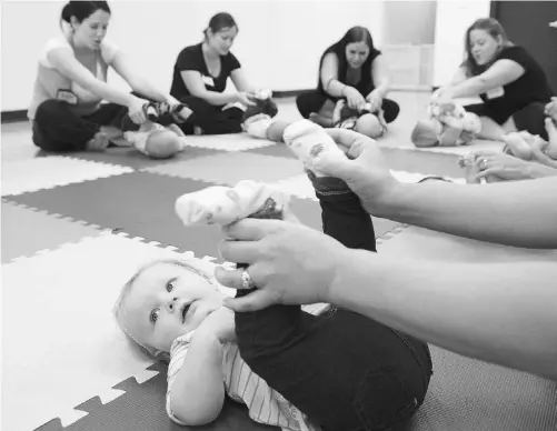  ?? LARRY WONG/ EDMONTON JOURNAL ?? Jenny Pelchat helps her 10-month-old Laura stretch during an Intellidan­ce class held at J’Adore Dance Studio.