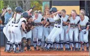  ?? Lorene Parker ?? Emma Evans comes home with her team celebratin­g with her in Game 1 against East Laurens.