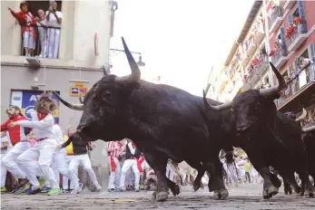  ?? FOTO: AFP ?? High Noon um 8 Uhr morgens: Lebensmüde hetzen mit 600-Kilogramm-Stieren durch Pamplona.