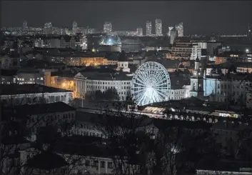  ?? Andrew Kravchenko The Associated Press ?? A view of Podil district during a blackout in Kyiv on Friday. Ukraine announced blackouts there and seven other regions after Russia’s strikes on energy infrastruc­ture.