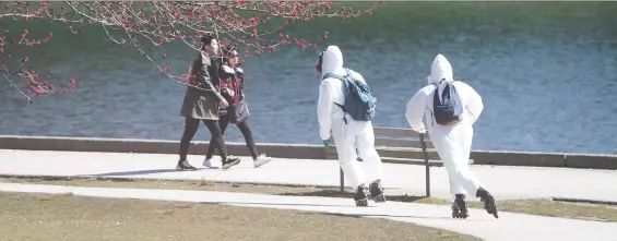  ?? DARRYL DYCK/THE CANADIAN PRESS/FILES ?? Two people wearing personal protective equipment skate on the seawall at Stanley Park. The pandemic is changing how people get around.