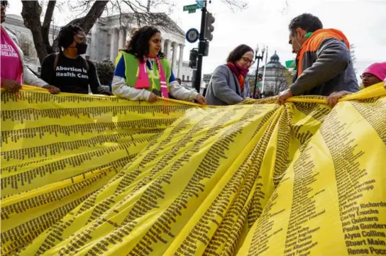  ?? AMANDA ANDRADE-RHOADES/ASSOCIATED PRESS ?? Abortion rights activists unfurled a banner with names of people who back access to medication abortion, outside the Supreme Court. Antiaborti­on activist Elise Ketch made her feelings known.