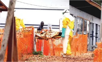  ?? — Reuters photo ?? Health workers are seen carrying a newly-admitted confirmed Ebola patient into a treatment centre in Butembo in the eastern Democratic Republic of Congo in this file photo.