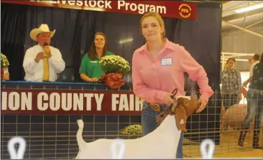  ?? Brittany Williams/News-Times ?? Junior Livestock Sale: Aubrey Hargett showcases her market price goat for buyers at the Junior Livestock Sale on Friday at the Union County Fair.