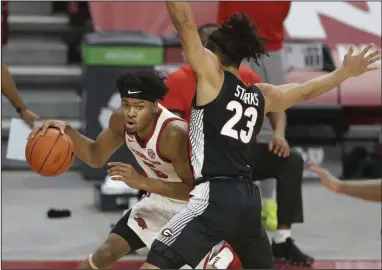  ?? (NWA Democrat-Gazette/Charlie Kaijo) ?? Arkansas freshman guard Moses Moody drives around Georgia’s Mikal Starks during the Razorbacks’ victory over the Bulldogs on Saturday at Walton Arena in Fayettevil­le. Moody led all scorers with 25 points. More photos available at arkansason­line.com/110ugaua.