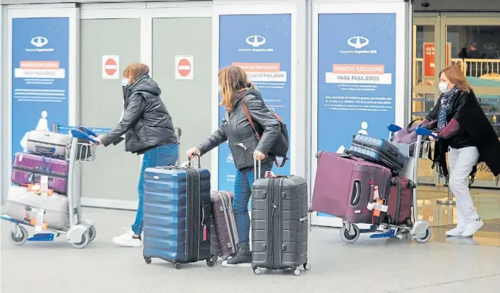  ?? FERNANDO DE LA ORDEN ?? “Afortunado­s”. Un grupo de argentinos en Ezeiza que logró regresar del exterior. Desde hoy podrán retornar por vía aérea sólo 900 por día.