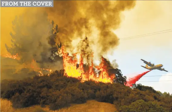  ?? Jose Luis Villegas / Sacramento Bee ?? Fire retardant is dropped near a home as the Mendocino Complex fire, the largest fire in California history, burns west of Lakeport (Lake County).