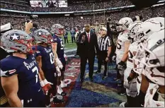  ?? Adam Hunger / Associated Press ?? Defense Secretary Lloyd Austin flips the coin before last year’s Army-Navy football game at MetLife Stadium in East Rutherford, N.J.