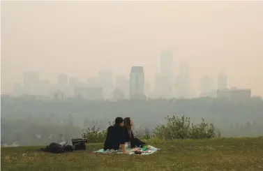  ?? JASON FRANSON/THE CANADIAN PRESS VIA AP ?? Smoke from wildfires blankets the city Saturday as a couple has a picnic in Edmonton, Alberta.