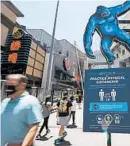  ?? MARK J. TERRILL/AP ?? People walk through Universal CityWalk on Thursday near Universal City, California.