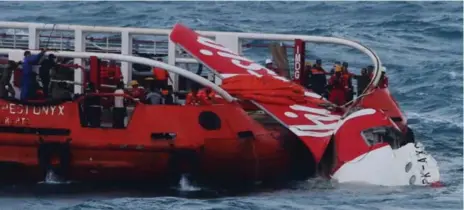  ?? AFP/GETTY IMAGES ?? Members of an Indonesian search and rescue team pull wreckage from AirAsia flight QZ8501 onto the Crest Onyx ship on Saturday.