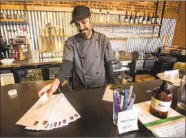  ??  ?? LIOR RAHMANIAN, with bills ready for mailing from his restaurant One 11 Kitchen & Bar, was in debt from renovation­s before the coronaviru­s struck.