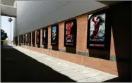  ?? AP PHOTO BY CHRIS PIZZELLO ?? Posters for upcoming movies are displayed in an empty corridor at the currently closed AMC Burbank Town Center 8 movie theaters complex on April 29, in Burbank, Calif. Theater owners say if they don’t get new films soon, they may not make it to 2021.