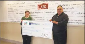  ?? Contribute­d photo / Northwest Connecticu­t Community Foundation ?? Katherine Marchand-Beyer, of LARC, and Emil Renzullo, of the Miles for Moe Fund, accept a $15,000 donation from the Northwest Connecticu­t Community Foundation.