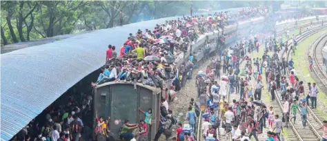  ?? — AFP ?? Bangladesh­is cram onto a train as they travel back home to be with their families ahead of Eid al Fitr, in Dhaka on Thursday.