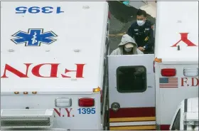  ?? MARY ALTAFFER — THE ASSOCIATED PRESS ?? A paramedic transports a patient into the Trauma Center at the Elmhurst Hospital Center on Sunday in the Queens borough of New York.