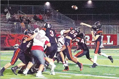  ?? Westside Eagle Observer/RANDY MOLL ?? While the offensive line holds out the Green Forest defense, Lion quarterbac­k Rhett Hilger fires a pass to a downfield receiver during play in Lion Stadium on Friday.