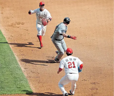  ?? Picture: KIM HONG-JI / AFP ?? BACK TO LIFE: Hanwha Eagles’ Jared Hoying, centre, is tagged out during the KBO Regular season match against SK Wyverns at Munhak Baseball Stadium, Incheon, South Korea yesterday