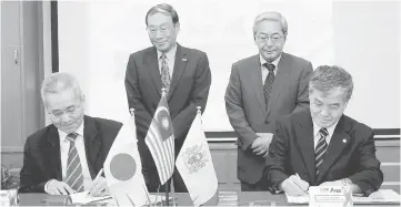  ??  ?? Dr Omar (left) and Dr Nabuhiko sign the memorandum of understand­ing as Yoshimura (standing left)) and Ryuji Noda look on. — Bernama photo