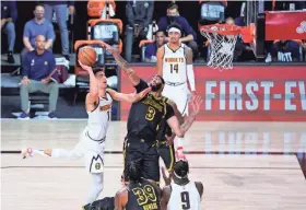  ?? MARK J. TERRILL/AP ?? The Nuggets’ Michael Porter Jr. (1) drives to the basket ahead of the Lakers’ Anthony Davis (3) during the first half on Sunday.