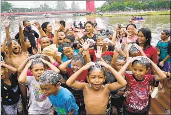  ?? TATAN SYUFLANA AP ?? Children bathe in the Cisadane River on the first evening of the holy fasting month of Ramadan in Tangerang, Indonesia, on Saturday, as they follow local tradition to symbolical­ly cleanse their soul.