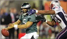  ?? THE ASSOCIATED PRESS FILE ?? Eagles quarterbac­k Donovan McNabb tries to escape the grasp of the Patriots’ Roosevelt Colvin during Super Bowl XXXIX in Jacksonvil­le, Fla.