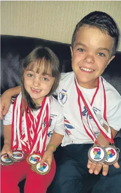  ??  ?? Skye and Finlay Davidson, from Inverkeith­ing, with the medals they won at the World Dwarf Games in Canada.