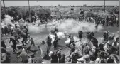  ??  ?? Palestinia­n worshipper­s run for cover from teargas, fired by Israeli forces, outside Jerusalem's Old City in front of the Al-Aqsa mosque compound on Friday.