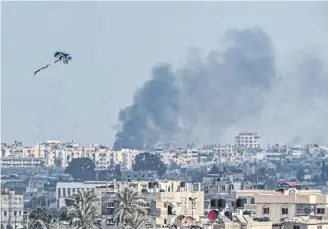  ?? PICTURE: SAID KHATIB/AFP VIA GETTY IMAGES ?? A kite is flown in Rafah as smoke billows following Israeli bombardmen­t on Khan Yunis