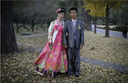  ?? WONG MAYE-E, THE ASSOCIATED PRESS ?? North Korean bride Ri Ok Ran, 28, and groom Kang Sung Jin, 32, pose for a portrait at the Moran Hill in Pyongyang. Their motto: “To have many children so that they can serve in the army and defend and uphold our leader and country, for many years into the future.”