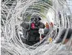  ??  ?? Protesters remove barbed wire at a barracks in Bangkok