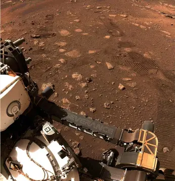  ??  ?? Left: Celebratio­ns occurred as Perseveran­ce left its first wheel tracks in the ruddy dust of Mars