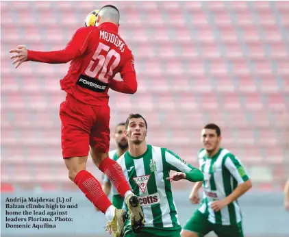  ??  ?? Andrija Majdevac (L) of Balzan climbs high to nod home the lead against leaders Floriana. Photo: Domenic Aquilina