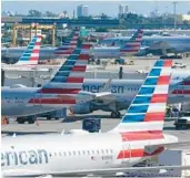  ?? MARTA LAVANDIER/AP ?? American Airlines planes are parked at Miami Internatio­nal Airport gates on Nov. 23, 2021. The airline helped propel the airport to ranking as busiest in Florida in 2022.