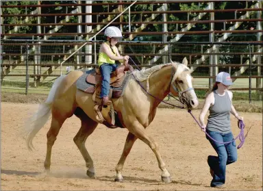  ?? PHOTOS BY MARK HUMPHREY ENTERPRISE-LEADER ?? Lennon Pitts, 5, a junior cowgirl who knows speed pays off. She spurred her horse a little too much causing the animal to overtake her mother, Alyssa Pitts, during the leadline speed race competitio­n at Sunday’s Lincoln Riding Club Play Day. Lennon took third in the event with a time of 14.065. Below, left, she dangles upside down by her boots from the Lincoln Riding Club Arena fence between events at Sunday’s Play Day. The junior cowgirl competed in three events.