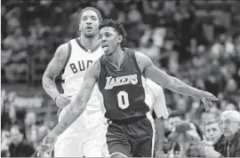  ?? Jeffrey Phelps Associated Press ?? NICK YOUNG reacts after draining a three-pointer during the second half at Milwaukee. Young led the Lakers with 26 points, including five three-pointers.