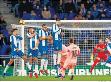  ?? QUIQUE GARCÍA / EFE ?? Messi supera la barrera del Espanyol para marcar el segundo de los goles de falta directa que anotó.