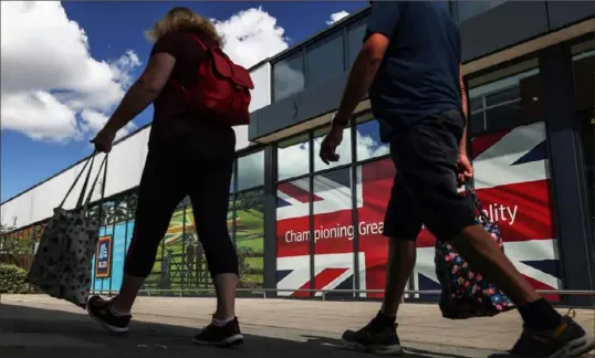  ?? Hollie Adams/Bloomberg ?? Shoppers outside an Aldi store in Strood, England. The German grocer, which opened its first store in the U.K. in 1990, earlier this month marked its 1,000th store opening in the U.K.