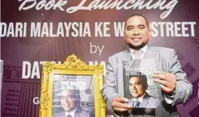  ?? BERNAMA PIC ?? Investment analyst Datuk Dr Nazri Khan Adam Khan showing the guidebook ‘Dari Malaysia Ke Wall Street’ at its launch in Putrajaya on Saturday.