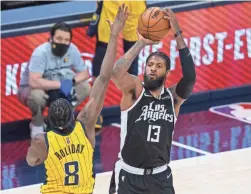  ?? TREVOR RUSZKOWSKI/USA TODAY SPORTS ?? Clippers guard Paul George (13) shoots the ball as Pacers forward Justin Holiday (8) defends on Tuesday.