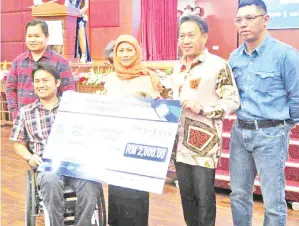  ??  ?? NANCY (tengah) menyampaik­an sumbangan kepada Persatuan Berkerusi Roda Kota Kinabalu.